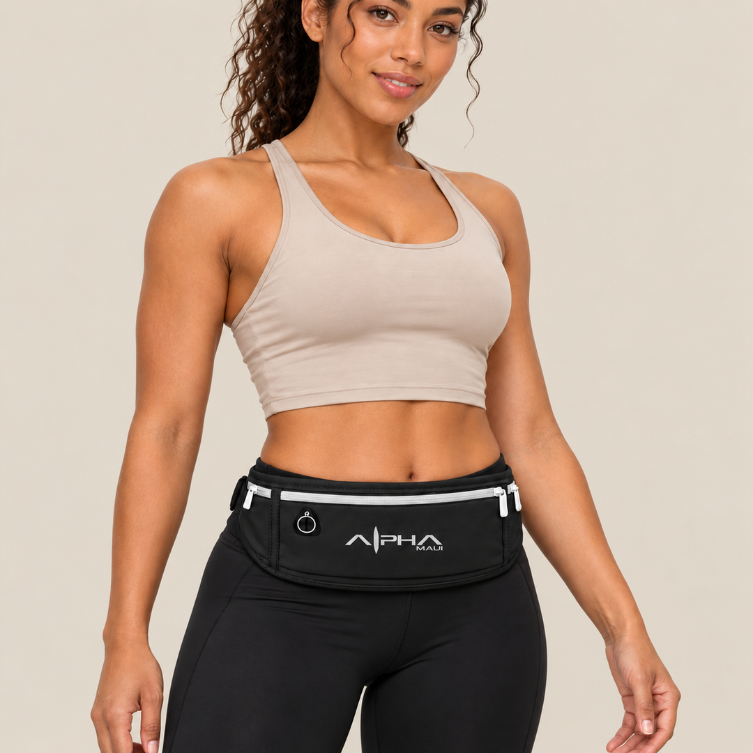 Model wearing black Alpha Maui waist pack, close-up on sand background