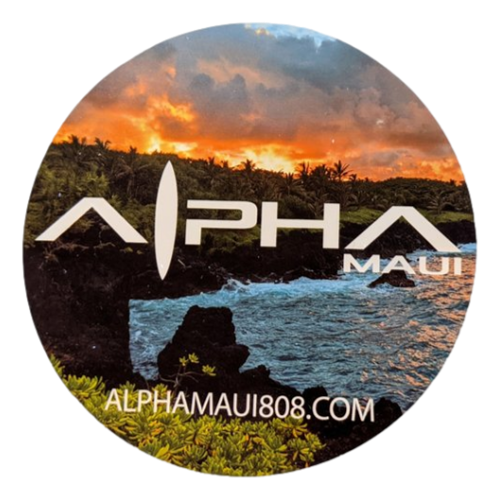 A round logo with "Let The Universe...Do It's Thing" in bold, stylized font against a dramatic sunset over a lush, green landscape and ocean waves. The text "alphamaui.com" is at the bottom, embodying the spirit of Aloha and the essence of Ohana in Hawaii.