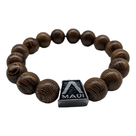 The Alpha Maui Band - Zebrawood 42mm (42-49mm) is a beaded bracelet crafted from polished wooden beads, featuring a central rectangular silver accent engraved with the 'Maui' logo and an 'A' shape. This design element symbolizes the Alpha Maui experience and evokes the spirit of Ohana in Hawaii.