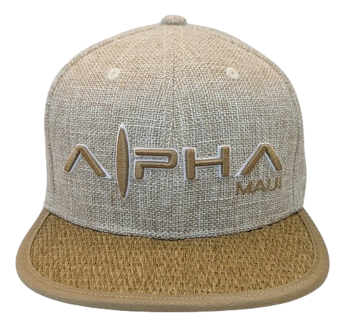 The Wailea Grand cap is a beige textured hat featuring "Alpha Maui" prominently embroidered in large letters on the front, with "Ohana" in smaller letters beneath it. The cap also boasts a curved brim with a distinct woven-like texture that perfectly captures the spirit of Hawaii.