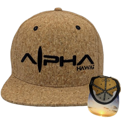 The "Good Vibes" snapback cap features a brown cork design with "Alpha Hawaii" embroidered in black letters on the front. The underside of the brim displays a vibrant coastal sunset image, highlighted in an inset view of the interior. Ideal for beachwear lovers, this cap captures the essence of Ohana and Alpha Maui.